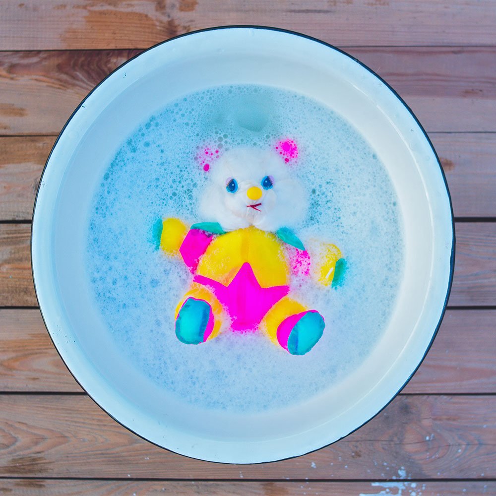 Child rescuing toys from ice in a fun science task from the Top 5 EYFS Activities for Summer
